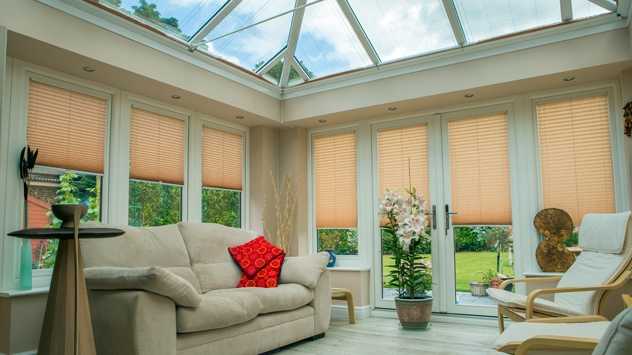 Remote control pleated roof blinds shown retracted in an orangery